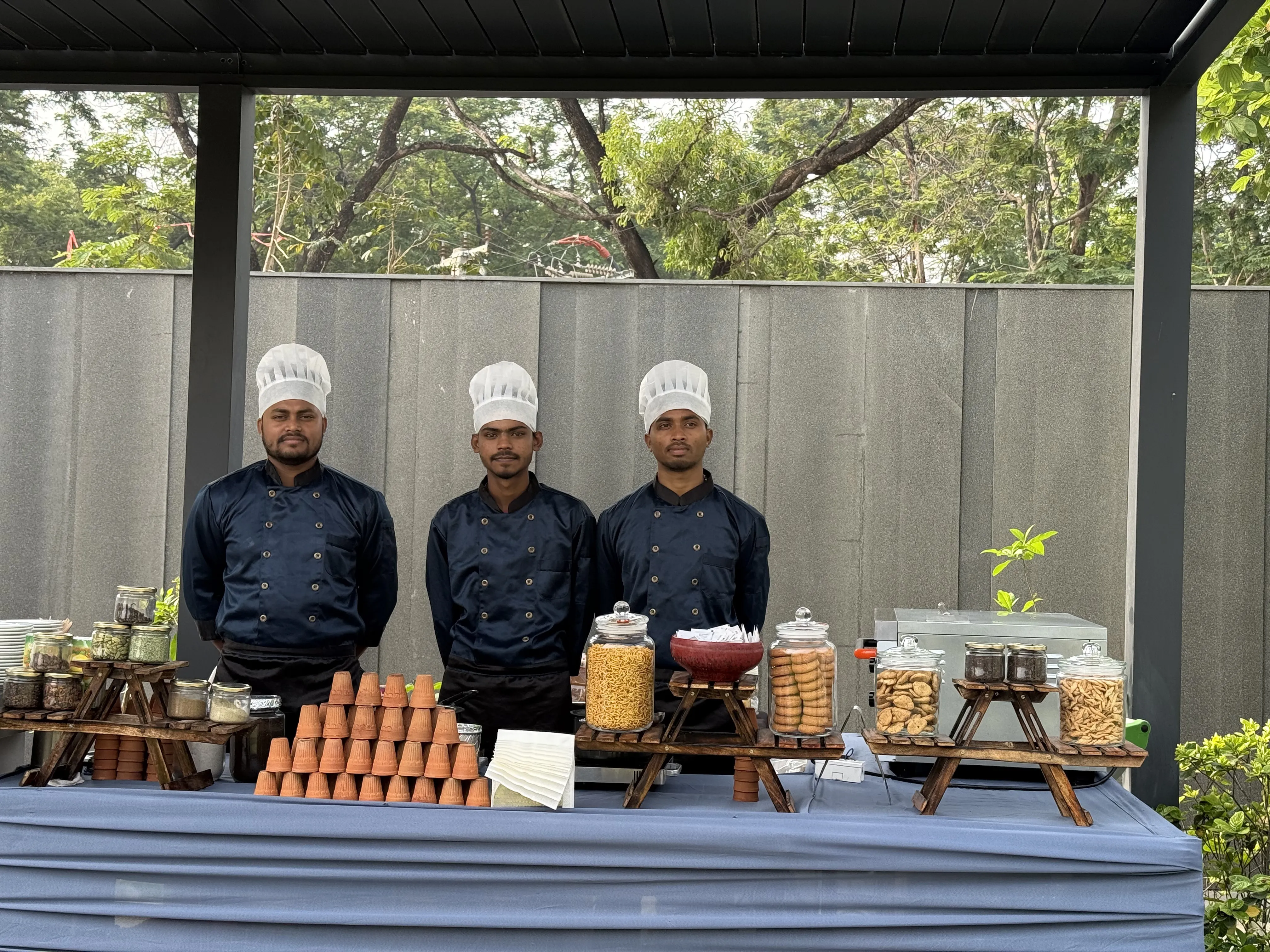 The Local Chai's uniformed crew behind a dressed catering counter with a kulhad pyramid